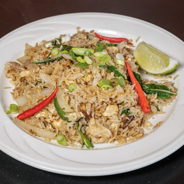 Lily Thai's fried rice with chicken, red chilies, green onions, and a lime wedge on a white plate.
